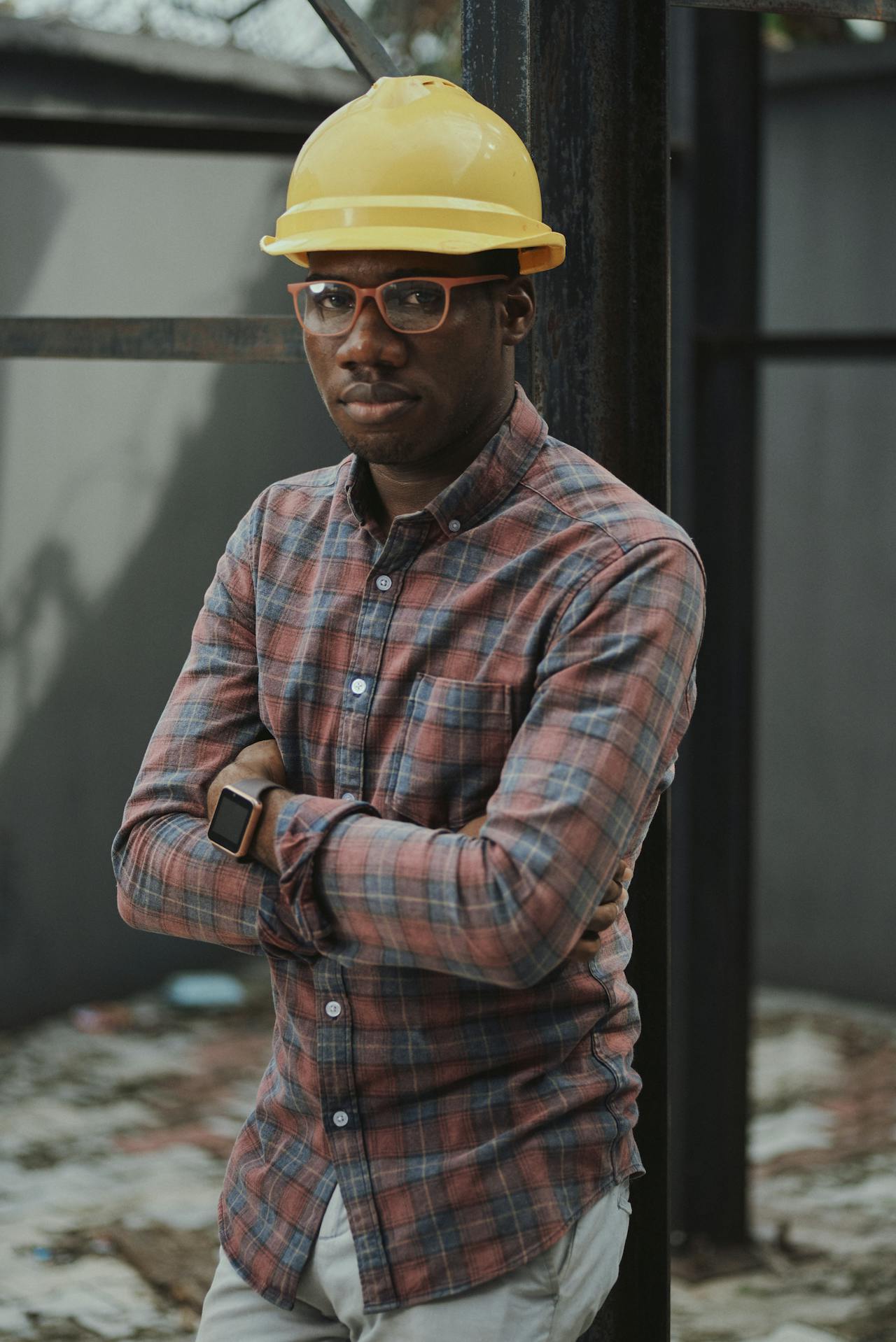 A black person wearing a yellow hard hat