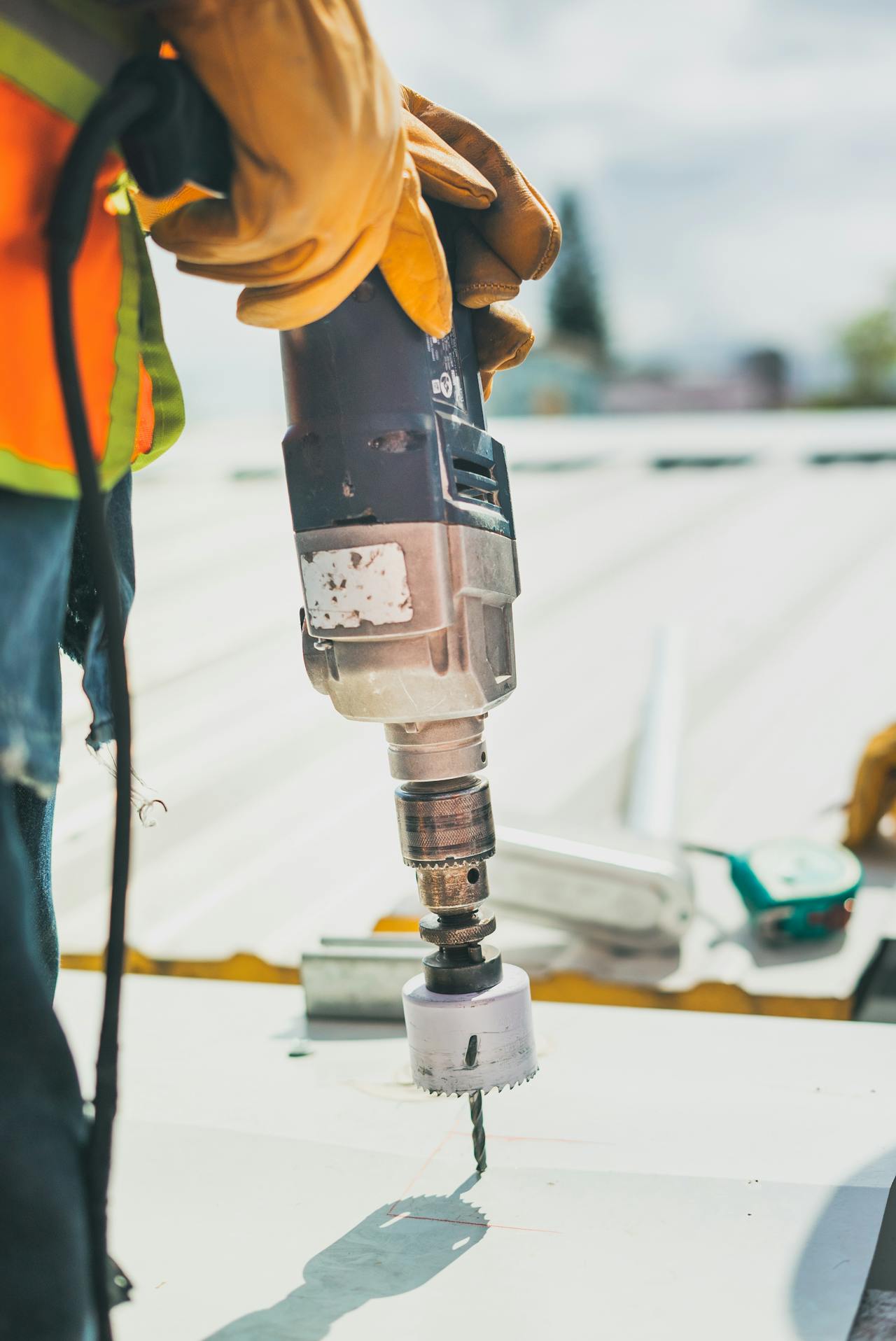 A person using a drill to drill holes in a metal surface